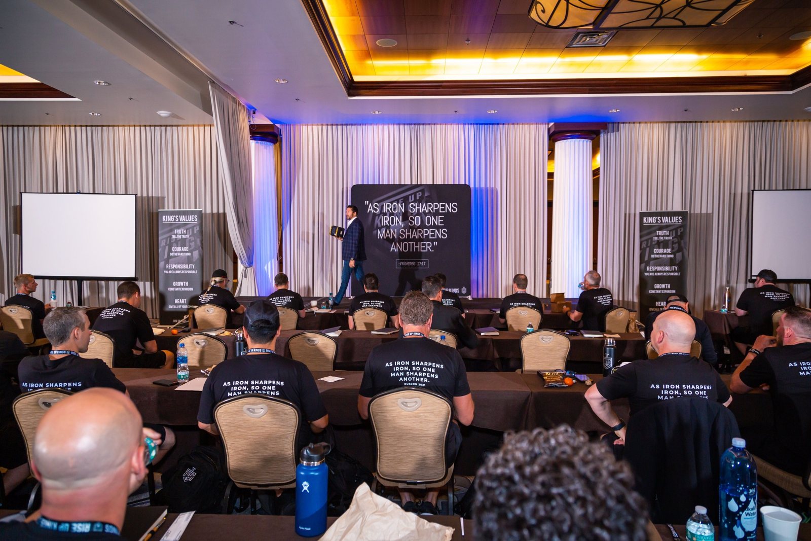 Skylar Lewis speaking on stage to a full room of CEOs and business owners